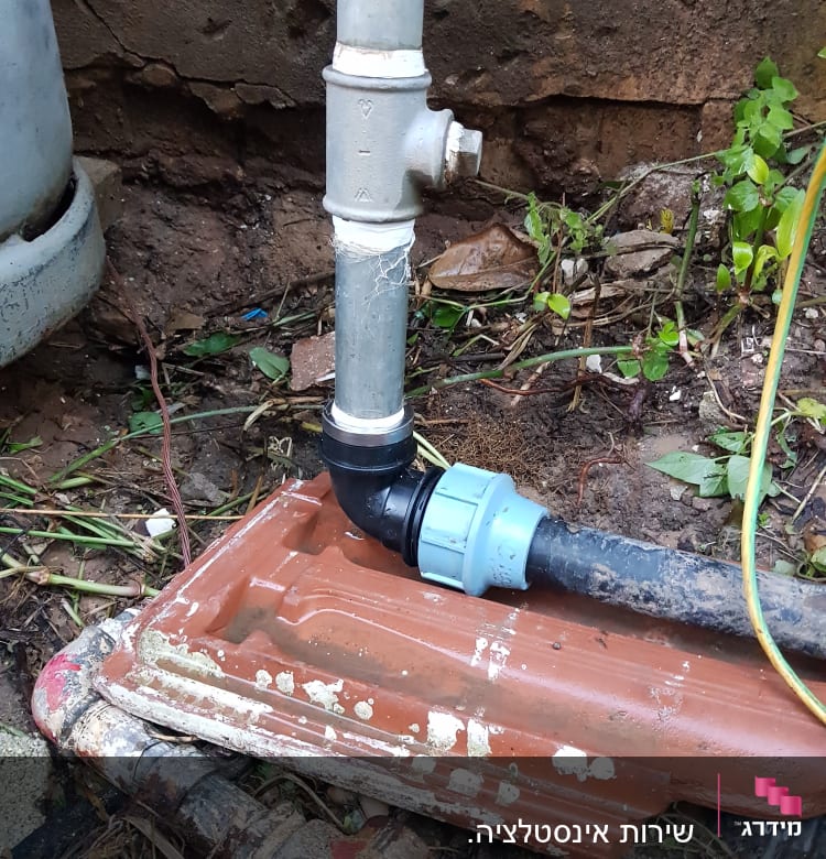 צינור מתכת מחובר לצינור פלסטיק עם מחבר